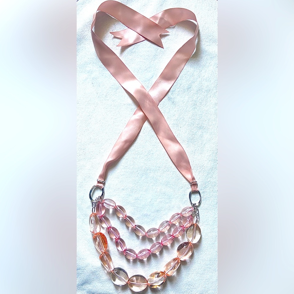 Necklace with pink ribbon, pink translucent stones and silver hardware.